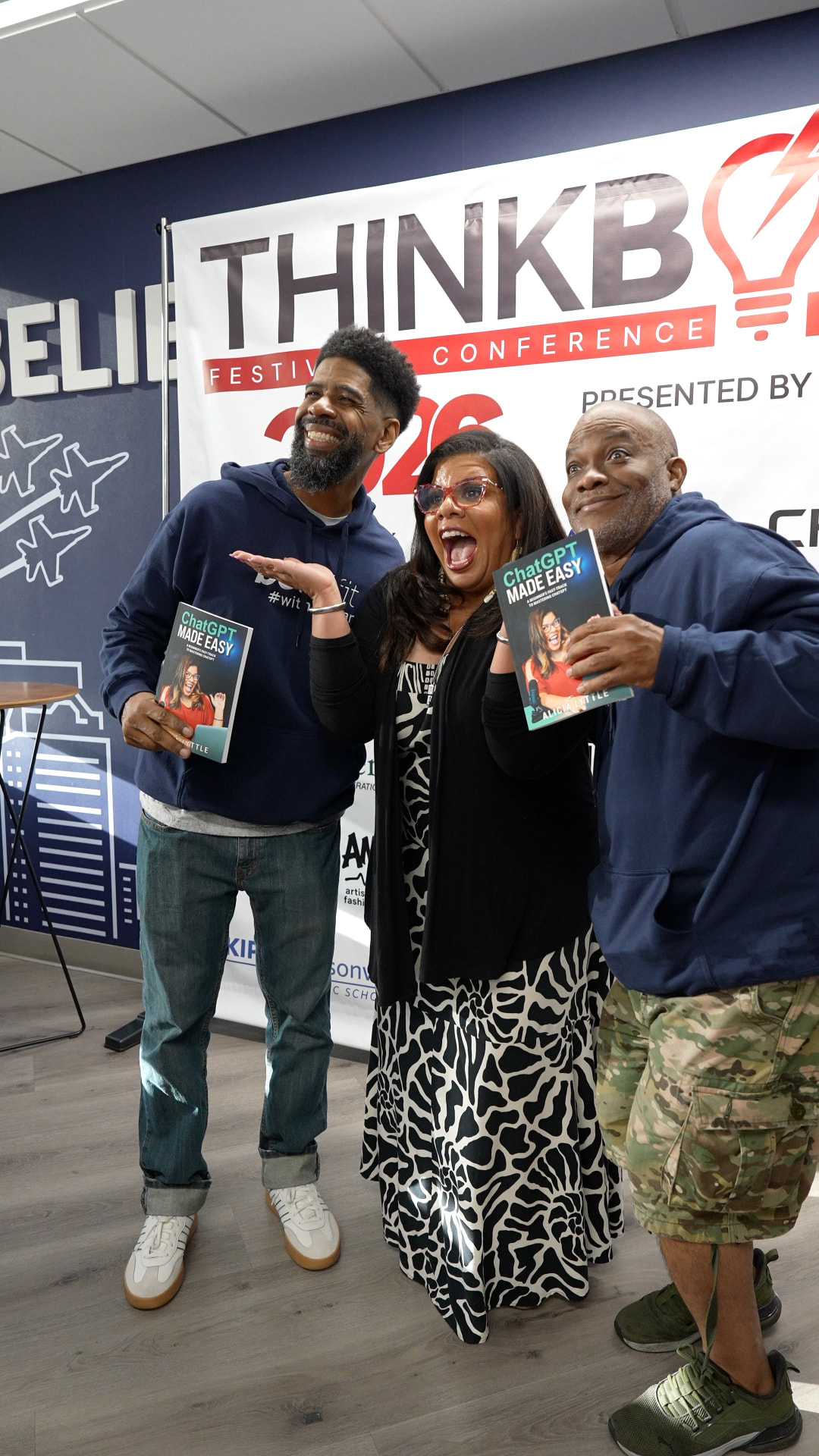Troy and Mo laughing with a guest holding ChatGPT Made Easy books at the GMG × VyStar mixer
