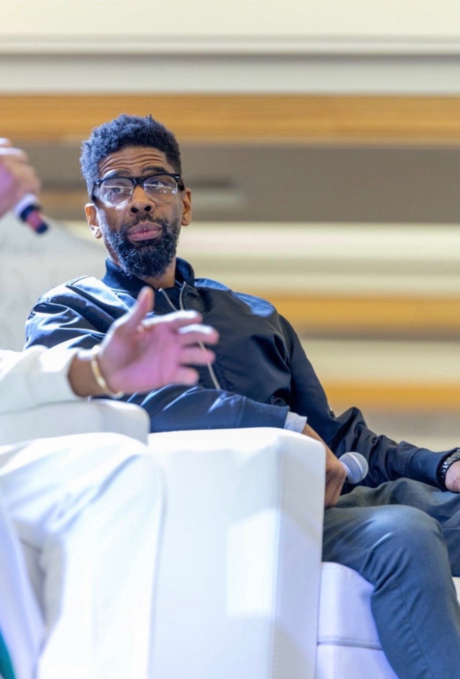 Troy seated on a festival panel, mid-conversation with a microphone in hand