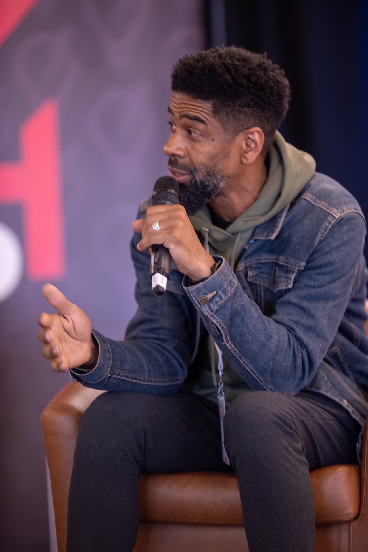 Maurice 'Mo' Henderson speaking on stage with a microphone